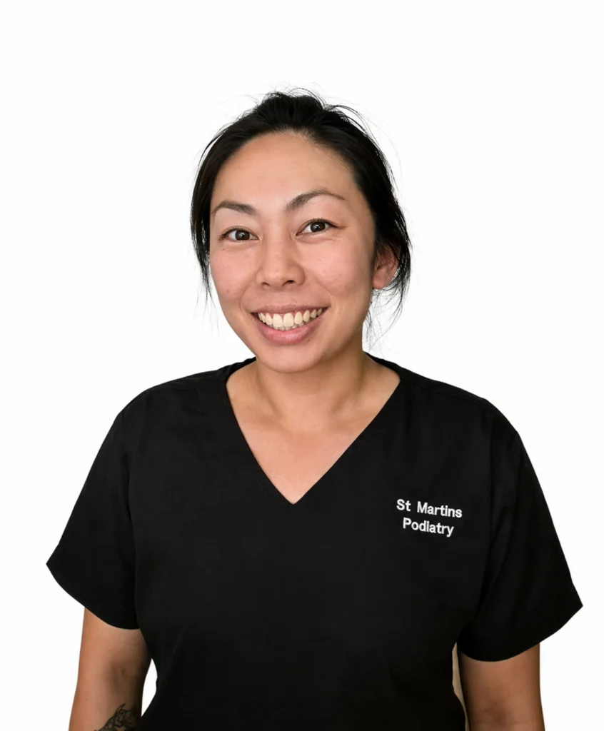 Portrait of a female healthcare professional in black medical scrubs from St Martins Podiatry.