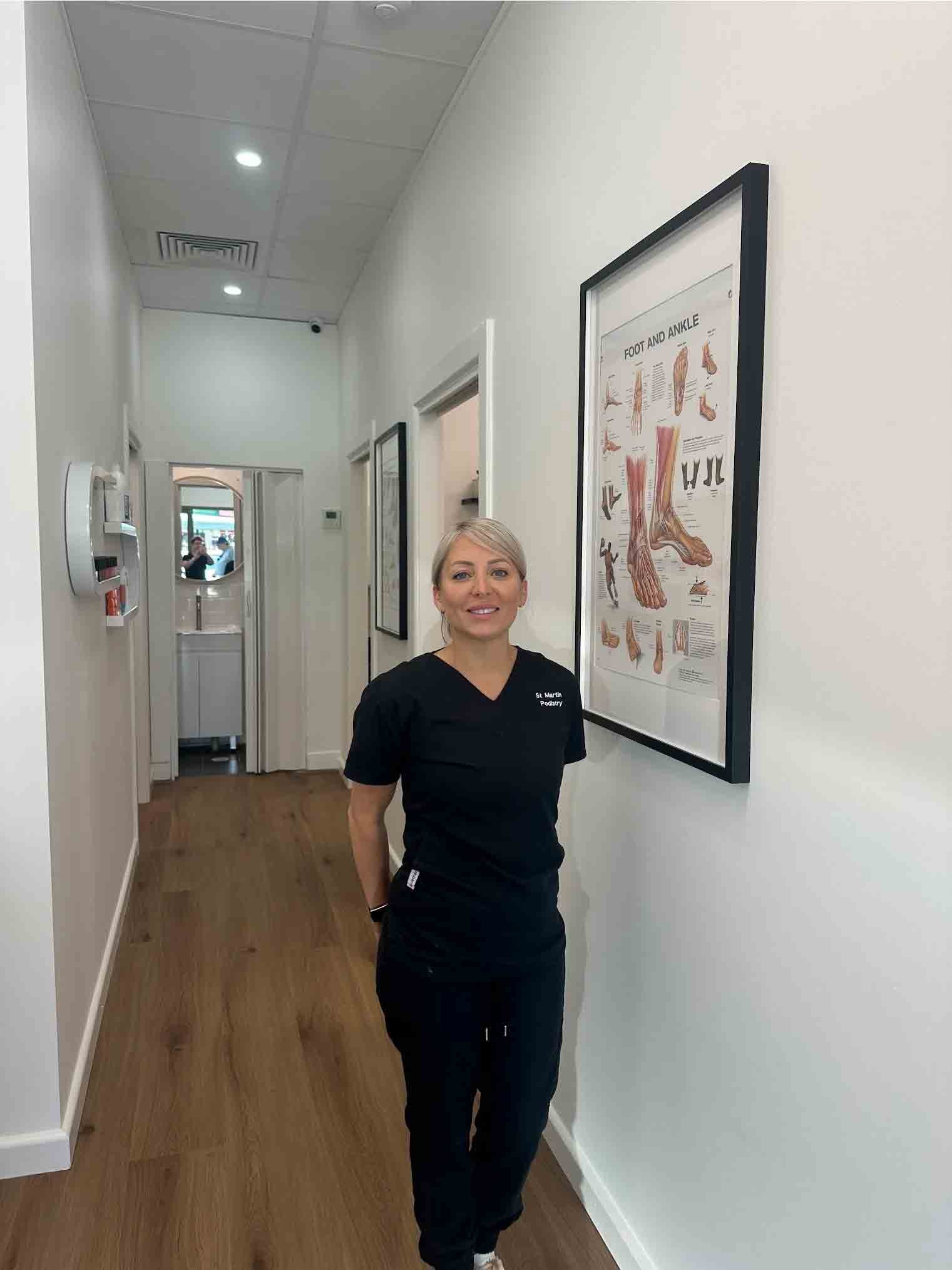 Female healthcare provider in black medical scrubs at St Martins Podiatry clinic.